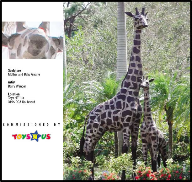 Statues of mother and baby giraffe in wooded area